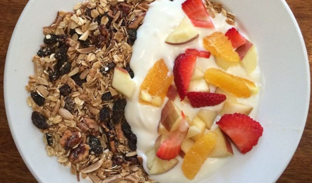 Bowl with granola, yogurt, and mixed fruit.